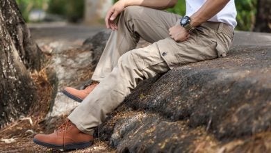 Man sitting on rock wearing beige cargo pants